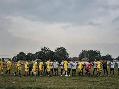Para pemain bersalaman sebelum bertanding dalam turnamen sepak bola antar kampung (Tarkam) di Desa Ragajaya, Bojong Gede, Kabupaten Bogor, Jawa Barat, Minggu (17/10/2021). (merdeka.com/Iqbal S. Nugroho)