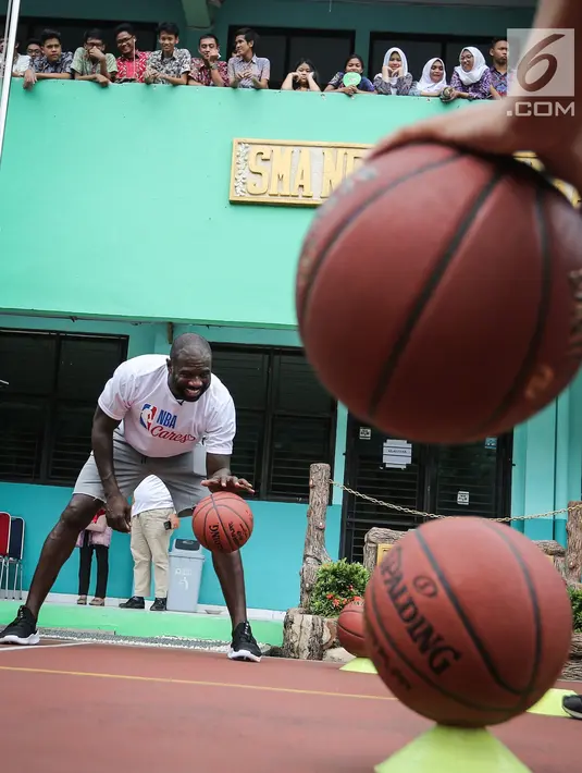 Mantan pemain NBA Jason Richardson melatih siswa-siswi pada program coaching clinic dan NBA Cares yang digelar Jr. NBA Indonesia di SMAN 82 Jakarta, Kamis (28/9). Jason Richardson merupakan Juara kontes slam dunk NBA 2002 dan 2003. (Liputan6.com/Fery Pradolo)