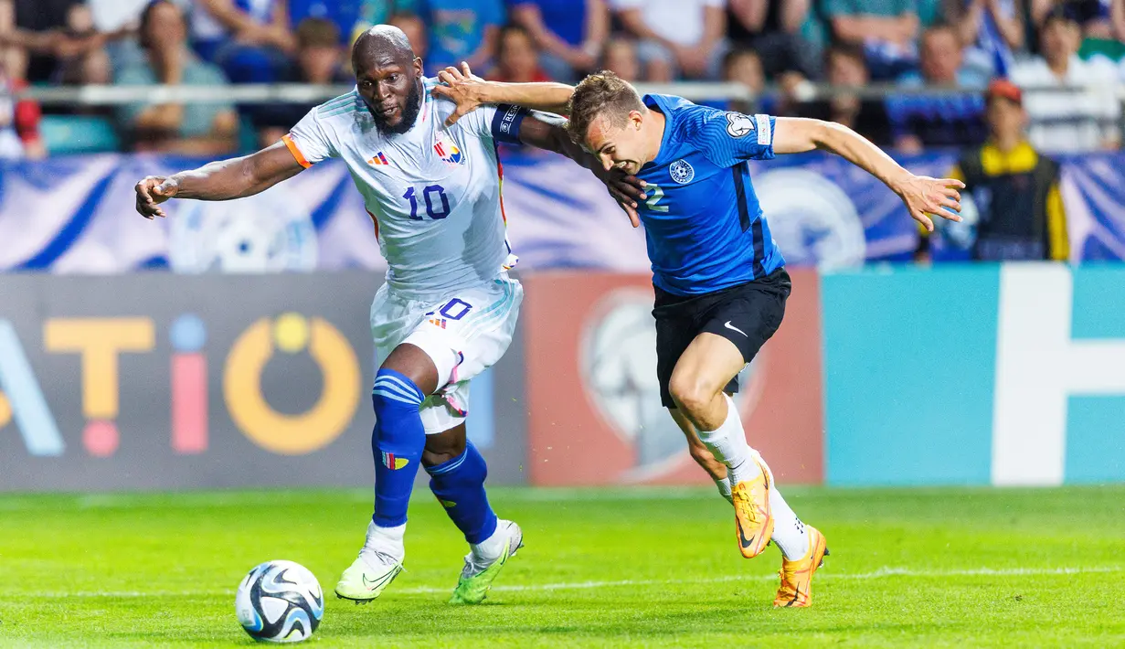 Pemain Belgia, Romelu Lukaku (kiri) berebut bola dengan pemain Estonia, Marten Kuusk pada laga Grup F Kualifikasi Euro 2024 yang berlangsung di A. Le Coq Arena, Tallinn, Estonia, Rabu (21/06/2023) dini hari WIB. Lukaku sukses mencetak dua gol untuk kemenangan 3-0 Belgia. (AP Photo/Pavel Golovkin)