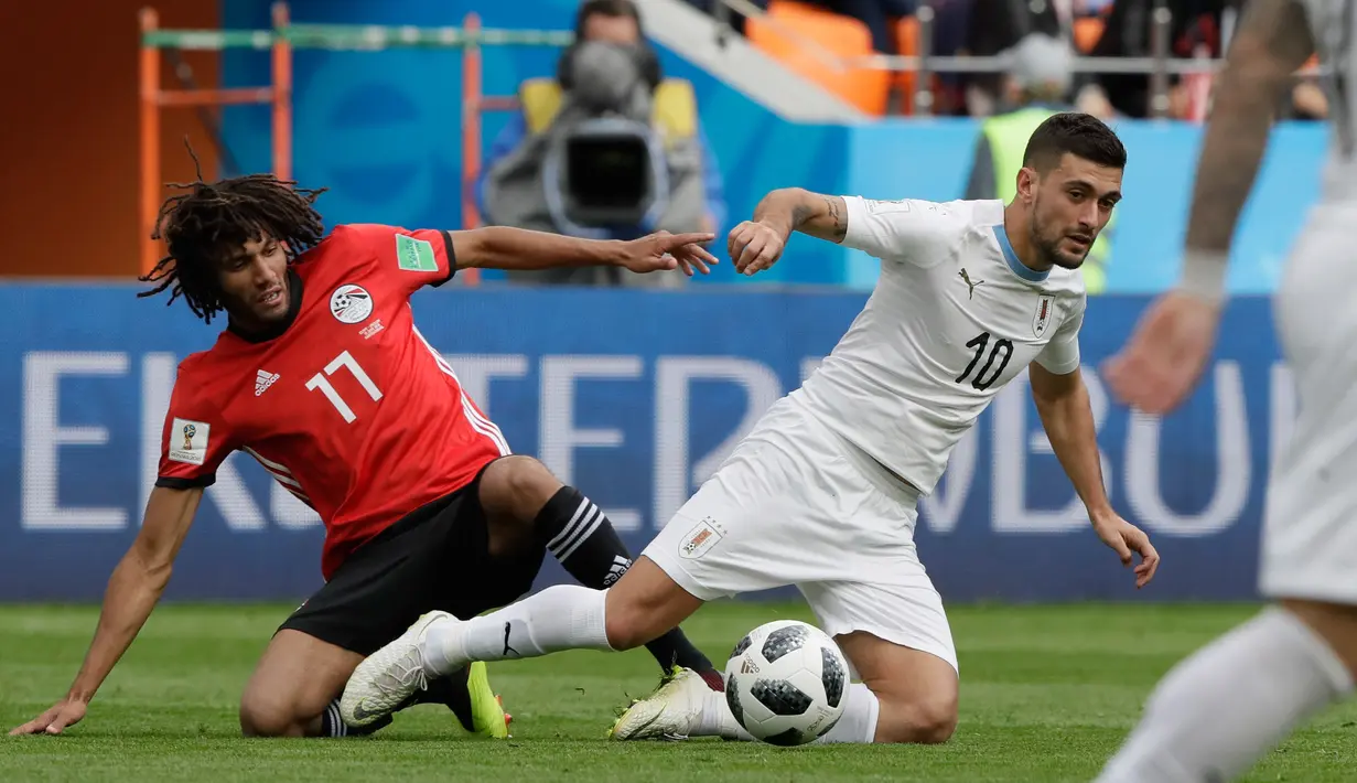 Pemain Mesir Mohamed Elneny (kiri) berebut bola dengan pemain Uruguay Giorgian De Arrascaeta saat bertanding pada grup A Piala Dunia 2018 di Yekaterinburg Arena, Rusia, (15/6). Uruguay menang dramatis atas Mesir 1-0. (AP Photo / Natacha Pisarenko)