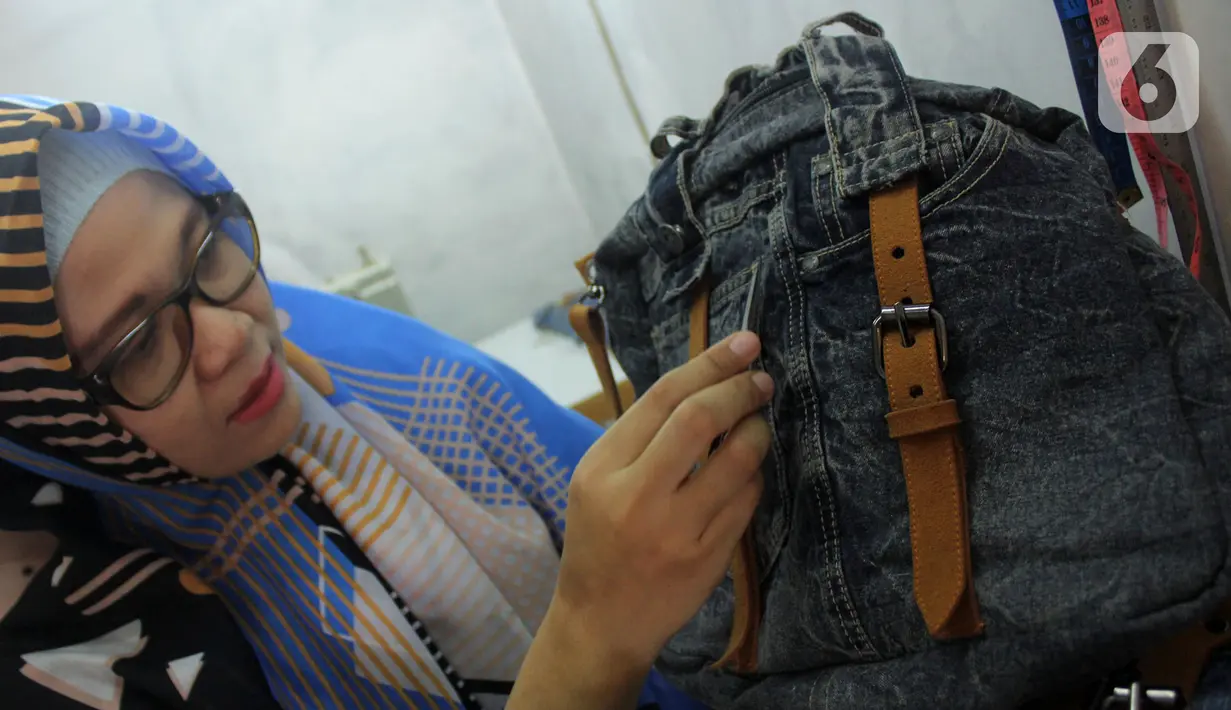 Perajin Risma Eljundi menunjukkan tas dari bahan celana jeans bekas di Legok, Tangerang, Banten, Senin (11/11/2019). Tas berbahan jeans dijual dengan harga Rp 150 ribu hingga Rp 250 ribu. (merdeka.com/Arie Basuki)