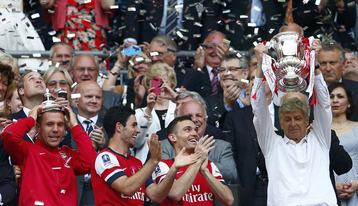 Pelatih Arsenal, Arsene Wenger (kanan) mengangkat trofi Piala FA usai menumbangkan Hull City 3-2 di Stadion Wembley, London, (18/5/2014). (REUTERS/Eddie Keogh)