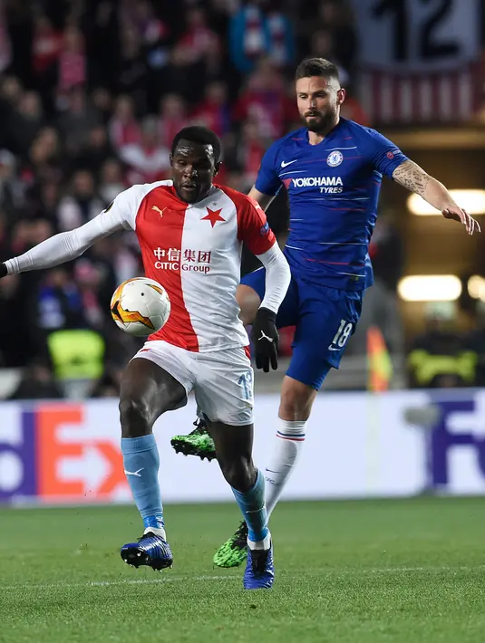 Bek Slavia Praha, Michael Ngadeu-Ngadjui berebut bola dengan striker Chelsea, Olivier Giroud dalam laga leg pertama perempat final Liga Europa 2018-19 di Sinobo Stadium, Kamis (11/4). Chelsea sukses meraih kemenangan atas Slavia Praha dengan skor tipis 1-0. (Michal CIZEK / AFP)
