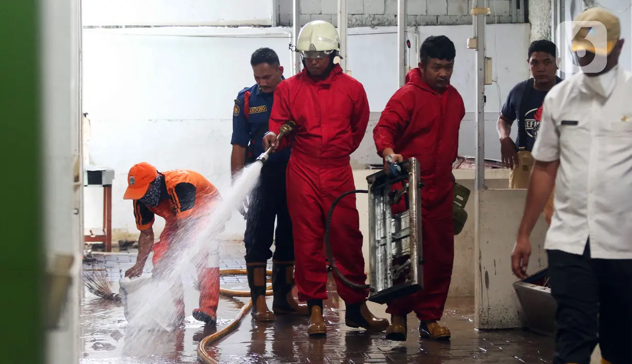 Petugas menyemprotkan air saat membersihkan ruangan di MTsN 19 Pondok Labu, Jakarta, Jumat (7/10/2022). Petugas PPSU, Satpol PP, dan Dinas Pemadam Kebakaran membersihkan ruang kelas, kantin, dan fasilitas lainnya usai terendam banjir pada Kamis sore kemarin. (Liputan6.com/Herman Zakharia)
