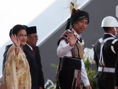 Presiden Joko Widodo atau Jokowi (kanan) bersama Ibu Negara Iriana melambaikan tangan saat tiba di lokasi Sidang Tahunan MPR dan Sidang Bersama DPR-DPD Tahun 2023 di Gedung Nusantara, Kompleks Parlemen, Senayan, Jakarta, Rabu (16/8/2023). Jokowi mengenakan baju adat Tanimbar, Maluku. (Liputan6.com/Johan Tallo)