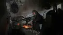 Di penghujung tahun 2025, krisis hunian bagi warga Palestina tetap berada pada tingkat yang sangat kritis akibat konflik yang berkepanjangan antara Israel dan Milisi Hamas di Jalur Gaza. Tampak dalam foto, Amani Halawa menghangatkan minuman di atas api di sebuah ruangan reyot, bertahan hidup di tengah reruntuhan rumahnya yang rusak di Jabaliya, Kota Gaza, Selasa, 25 November 2025. (AP Photo/Jehad Alshrafi)