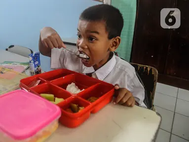 Siswa menyantap makanan saat mengikuti uji coba pelaksanaan program makan bergizi gratis di SDN 4 Tangerang, Kota Tangerang, Banten, Senin (5/8/2024). (merdeka.com/Arie Basuki)
