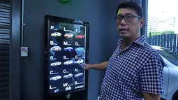 GM Autobahn Motors, Gary Hong menunjukan layar sentuh untuk membeli mobil dari vending machine atau mesin penjual otomatis, Kamis (18/5). Konsep vending machine ini bertujuan memanfaatkan secara efisien lahan di Singapura yang terbatas (ROSLAN RAHMAN/AFP)
