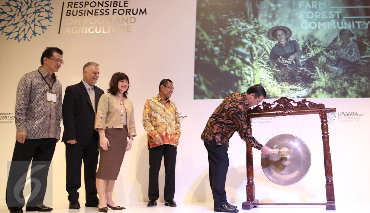 Menteri Pertanian, Amran Sulaiman (kanan) memukul gong saat membuka seminar Responsible Business Forum on Food And Agriculutre di Jakarta, Senin (25/4). Forum ini memfokuskan upaya meningkatkan produktivitas bidang pertanian (Liputan6.com/Faizal Fanani)