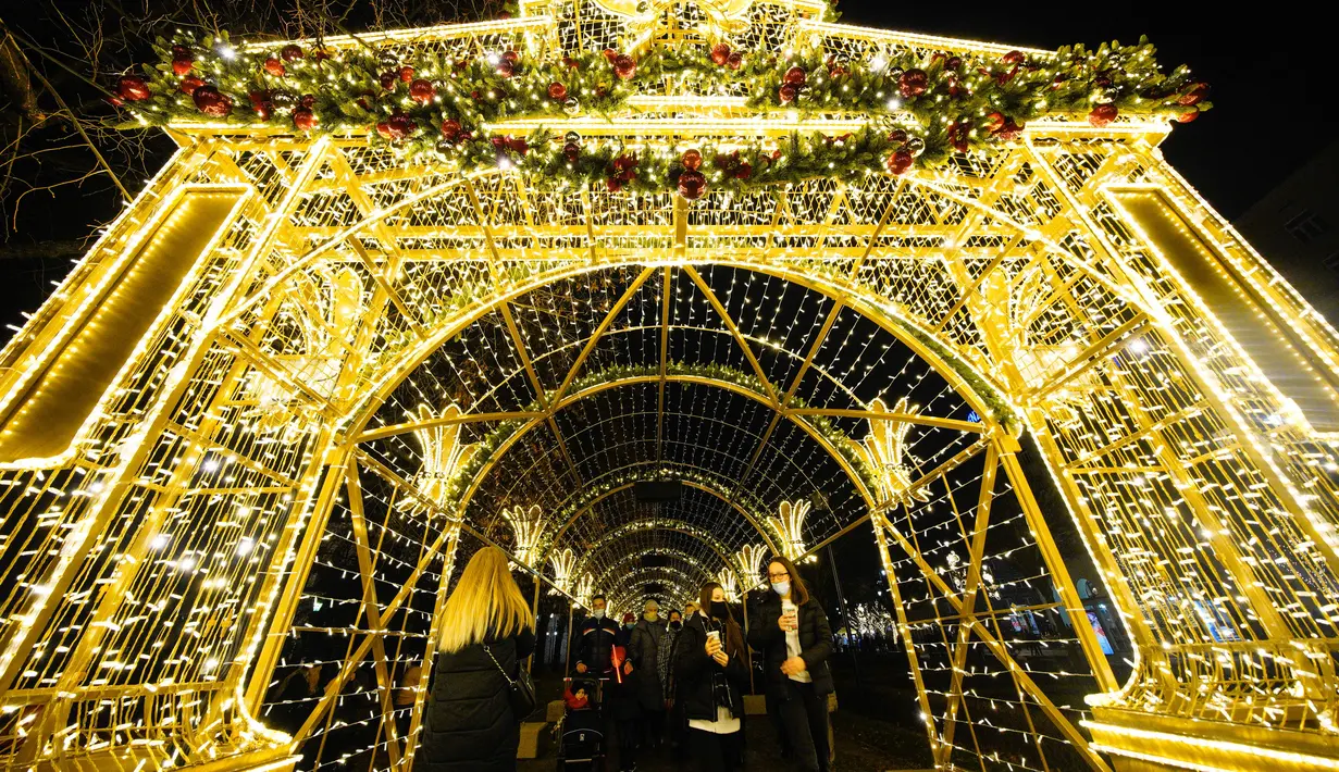 Orang-orang berjalan melewati sejumlah instalasi Natal yang diterangi lampu di Warsawa, Polandia, pada 5 Desember 2020. Dinyalakannya lampu pohon Natal besar di Castle Square di Warsawa pada Sabtu (5/12) menandai pembukaan resmi musim Natal di Polandia. (Xinhua/Jaap Arriens)