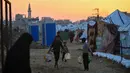 Kondisi ini memaksa warga Gaza bergantung pada distribusi bantuan air bersih dengan jumlah yang terbatas. Tampak dalam foto, anak-anak membawa air di kamp Nuseirat untuk pengungsi Palestina di Jalur Gaza tengah pada Kamis 4 Desember 2025. (Eyad Baba/AFP)