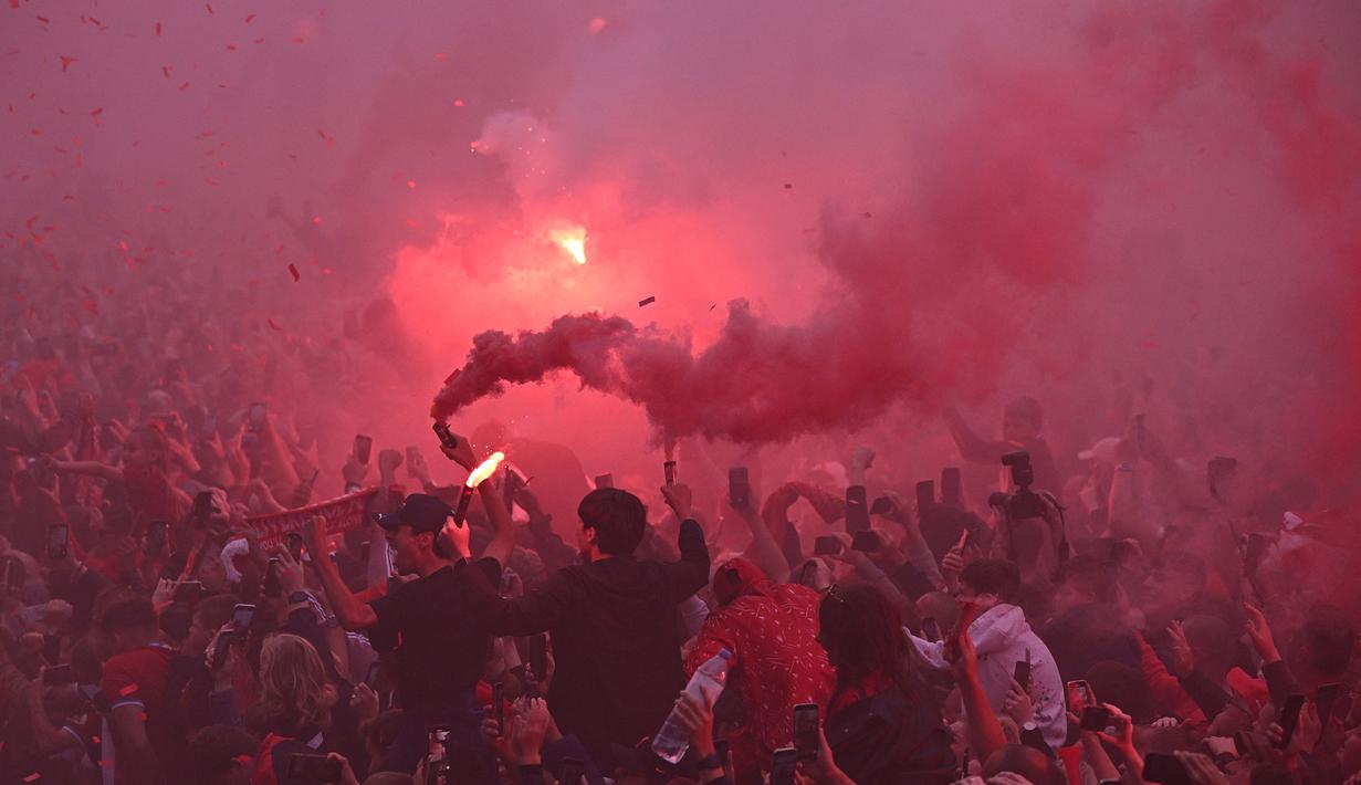 Ribuan fans Liverpool memadati jalan-jalan kota untuk menyambut tim kebanggaan mereka yang melakukan parade di atas bus terbuka pada Minggu (29/05/2022) waktu setempat. Musim ini, The Reds berhasil meraih dua trofi yaitu Piala FA dan Piala Liga Inggris. (AFP/Oli Scarff)