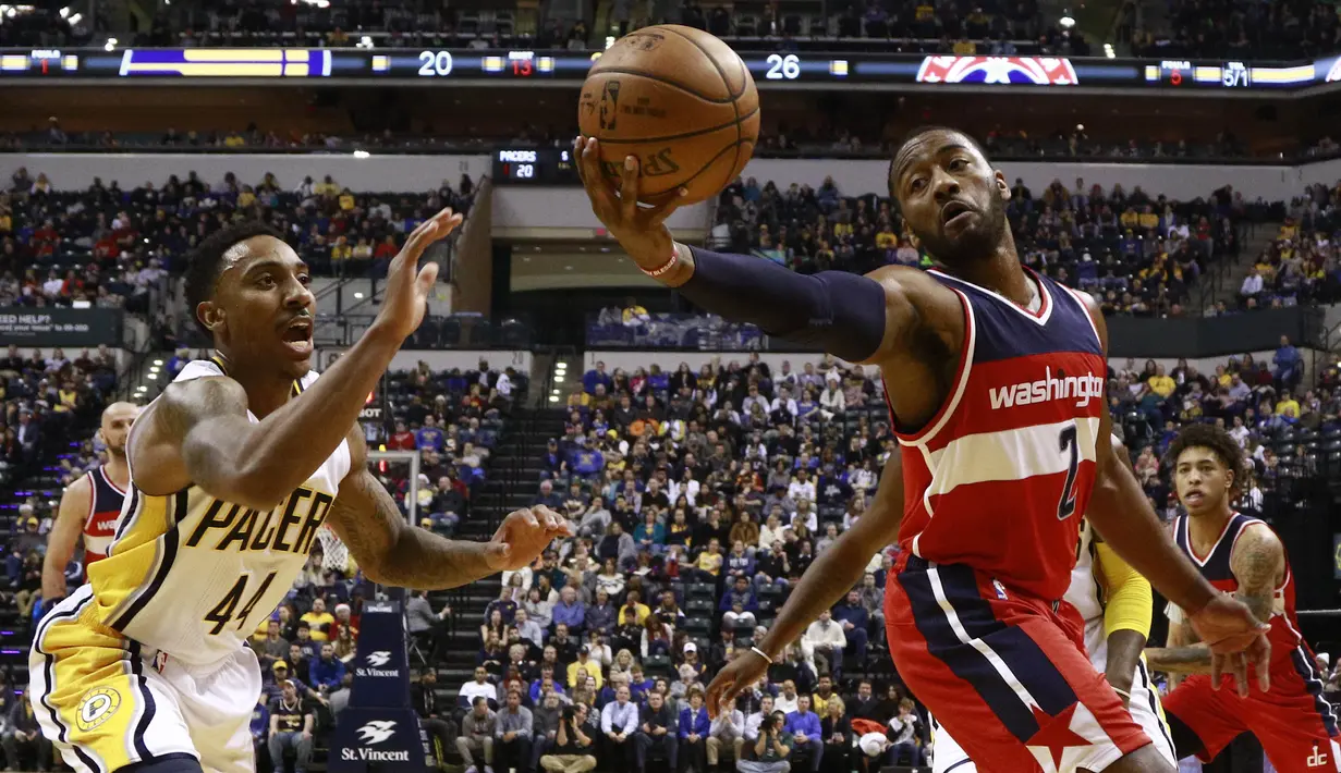 Aksi pemain Washington Wizards, John Wall (2) mengontrol bola saat berduel dengan pemain Indiana Pacers, Jeff Teague (kiri) pada laga NBA basketball game di Bankers Life Fieldhouse, Indianapolis, (19/12/2016). (AP/R Brent Smith)