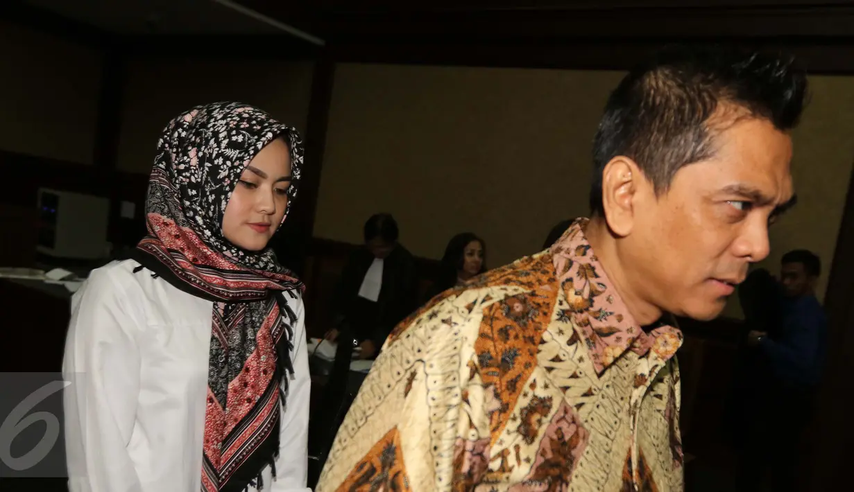 Terdakwa dugaan suap Raperda Teluk Reklamasi, M Sanusi dan istrinya, Evelien, seusai menjalani sidang di Pengadilan Tipikor, Jakarta, Senin (3/10). JPU KPK menghadirkan sejumlah saksi, diantaranya istri Sanusi, Evelien. (Liputan6.com/Helmi Afandi)