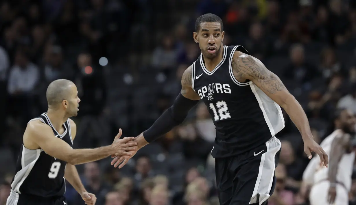 Pemain San Antonio Spurs, LaMarcus Aldridge (12) dan rekannya Tony parker (9) merayakan keberhasilan mencetak poin  pada lanjutan NBA di basketball game di AT&T Center, San Antonio, (23/1/2018). Spurs menang atas Cleveland 114—102. (AP/Eric Gay)