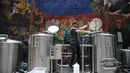 Pekerja mengecek proses pembuatan bir yang botolnya bergambar Presiden AS Donald Trump di perusahaan Cru Cru Brewery di Mexico City (15/6). Meski kontroversial penjualan bir ini sangat cepat laku di tempat tersebut. (AFP Photo/Bernardo Montoya)