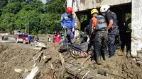 Badan Nasional Penanggulangan Bencana (BNPB) menegaskan bahwa seluruh unsur pemerintah daerah, TNI–Polri, Basarnas, kementerian/lembaga, serta relawan terus mengerahkan sumber daya untuk mempercepat pencarian korban. Tampak dalam foto, tim penyelamat mengevakuasi jenazah korban banjir di Padang Panjang, Sumatera Barat, Senin 1 Desember 2025. (AP Photo/Ali Nayaka)