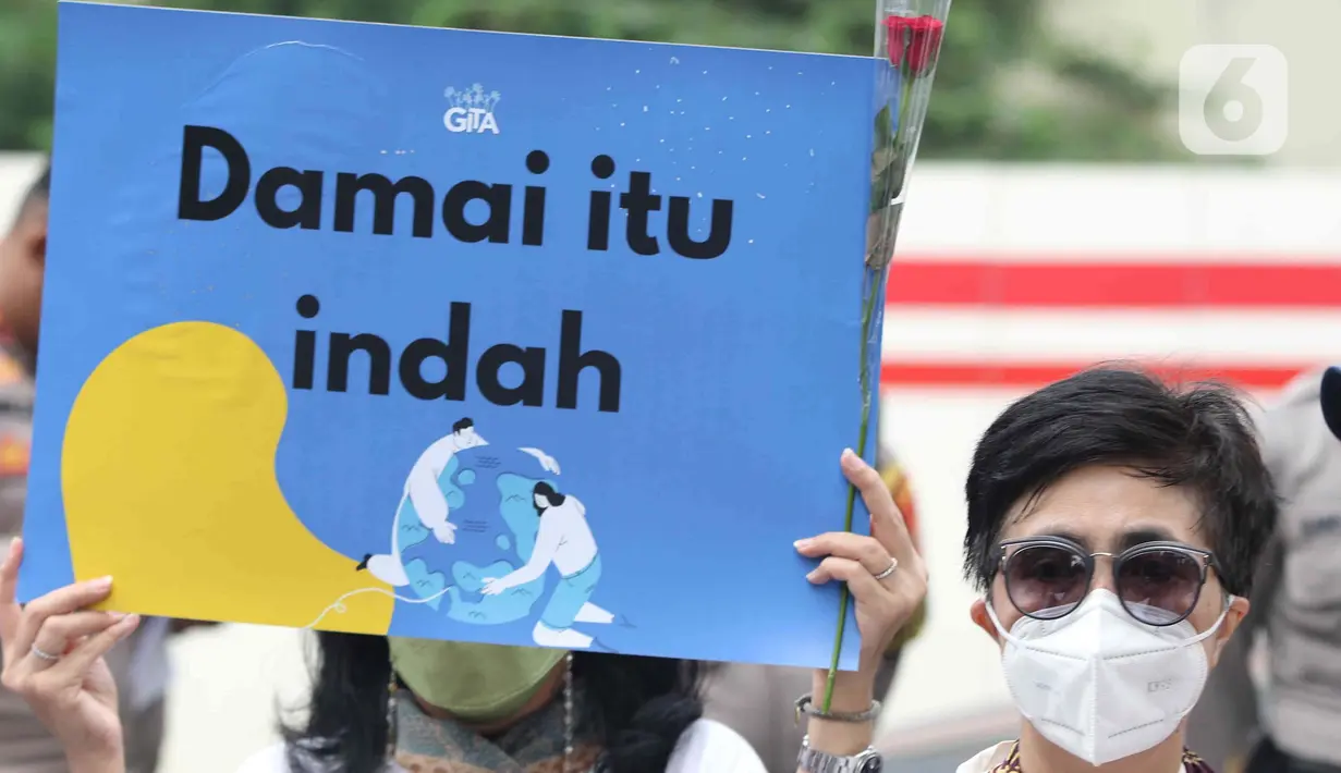 Peserta aksi seruan damai di Kedutaan Besar Federasi Rusia, Jakarta, Rabu (30/3/2022). Aksi mengangkat tema "Setangkai Kembang dan Satu Nyanyian" dengan membawakan lagu Rayuan Pulau Kelapa versi bahasa Rusia dalam bentuk dukungan perdamaian antara Rusia dan Ukraina. (Liputan6.com/Herman Zakharia)