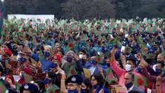Para pejabat Bangladesh dan lainnya mengibarkan bendera nasional saat perayaan 50 tahun kemenangan atas Pakistan pada sebuah acara di Dhaka, Bangladesh, 16 Desember 2021. Pada 16 Desember 1971, tentara Pakistan menyerah kepada pasukan gabungan India-Bangladesh. (AP Photo/Mahmud Hossain Opu)