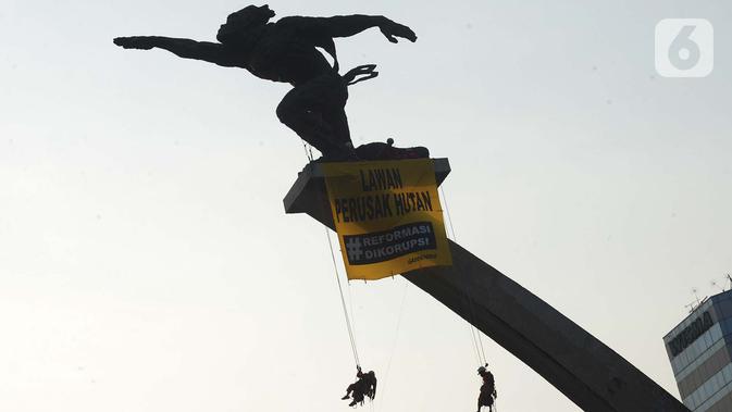 Sejumlah orang membentangkan spanduk di Patung Dirgantara Pancoran, Jakarta, Rabu (23/10/2019). Aksi tersebut dilakukan untuk mendapat perhatian khusus dari Presiden Joko Widodo atau Jokowi dan para menteri barunya untuk memukul mundur krisis iklim. (merdeka.com/Imam Buhori)