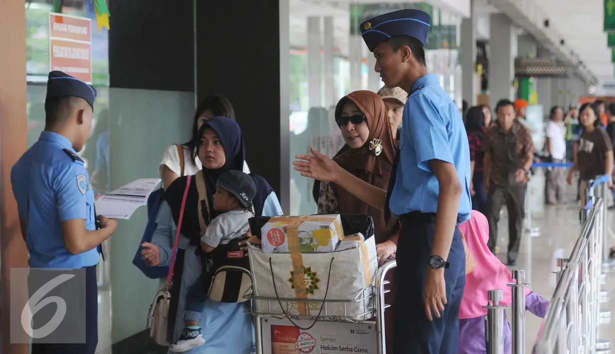 Petugas memeriksa kecocokan tiket calon penumpang pesawat di Bandara Halim Perdanakusuma Jakarta, Senin (4/7). H-2 jelang Idul Fitri 1437 H, ribuan calon penumpang diberangkatkan dari Bandara Halim Perdanakusuma. (Liputan6.com/Helmi Fithriansyah)