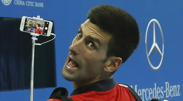 Petenis  Novak Djokovic melakukan selfie bersama fans usai mengalahkan petenis Italia Simone Bolelli di China Open tennis tournament, Beijing, China, Selasa (06/10/2015).  (REUTERS/Kim Kyung-Hoon)