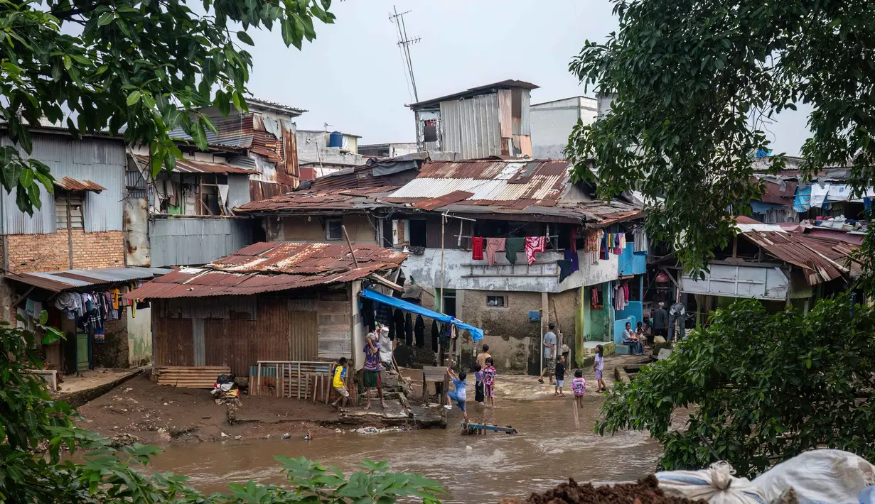 Menurut Badan Pusat Statistik (BPS), pada tahun 2026, Jakarta Pusat menjadi daerah dengan kepadatan penduduk tertinggi di Jakarta, yaitu sekitar 21.699 jiwa per km persegi. Tampak dalam foto, anak-anak yang tinggal di permukiman padat penduduk di tepi sungai bermain air saat permukaan air naik di Jakarta pada Selasa 21 April 2026. (BAY ISMOYO/AFP)