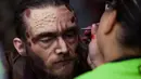 Seorang pria dibantu berdandan sebelum Zombie Walk di Mexico City, Minggu (11/11). Dalam acara tahunan itu ratusan orang dengan penampilan yang seram dan mengenakan pakaian compang-camping berkumpul di pusat bersejarah ibu kota Meksiko. (AP/Claudio Cruz)