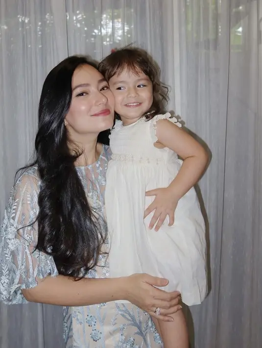 Dress putih tersebut dibuat oleh Darcy Rae. Ia pun bergaya bak model saat berfoto bersama sang mamah tercinta. Credit: Instagram (@asmirandah89)