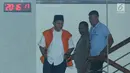 Bupati Lampung Tengah Mustafa (kiri) tertunduk saat menuruni tangga Gedung KPK, Jakarta, Selasa (20/2). Mustafa diperiksa sebagai saksi dugaan suap persetujuan pinjaman daerah untuk APBD Lampung Tengah TA 2018. (Liputan6.com/Helmi Fithriansyah)