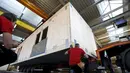 Pegawai bangunan saat merekonstruksi sebuah rumah prefabrikasi untuk pengungsi di perusahaan konstruksi Bauer Holzsysteme, Jerman, (7/12).  Rumah prefabrikasi ini dapat diangkut dan dipindahkan dengan menggunakan truk angkut. (REUTERS/Michaela Rehle)