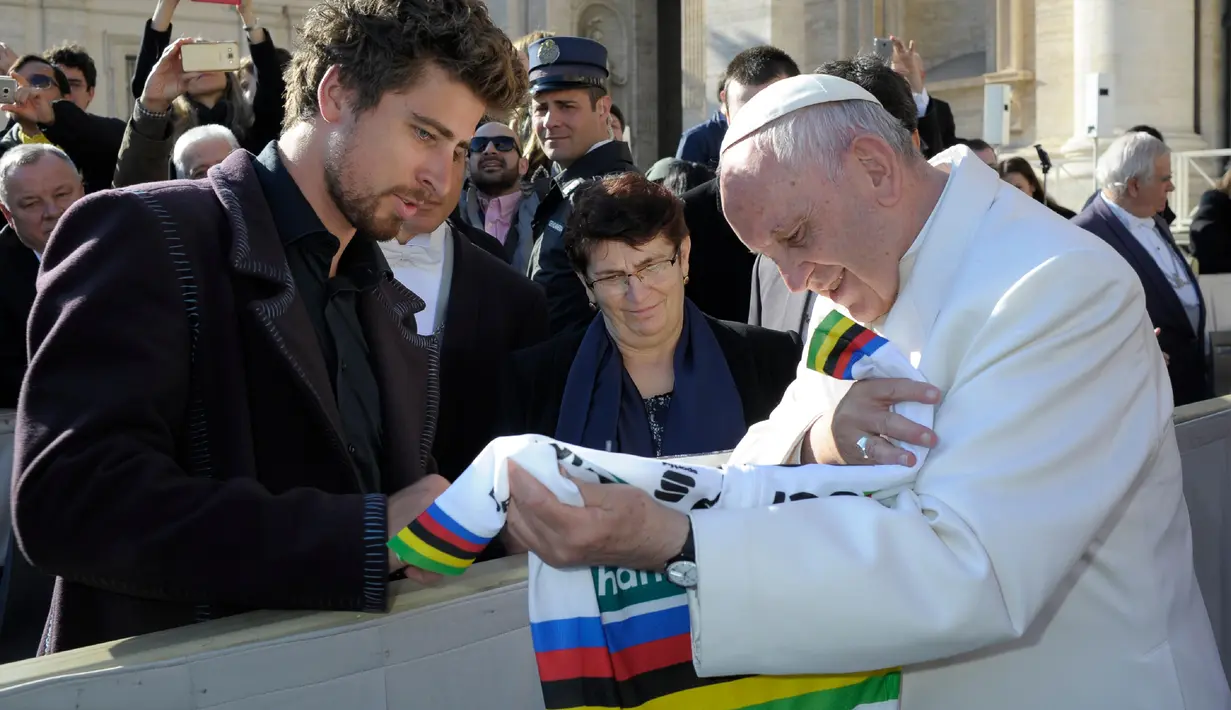 Paus Fransiskus melihat jersey yang diberikan oleh Peter Sagan pada akhir audiensi mingguan di Vatikan (24/1). Peter Sagan merupakan pebalap pertama yang memenangkan gelar juara dunia elit putra tiga kali berturut-turut. (AFP/HO/Osservatore Romano)