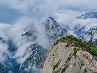 Foto dari udara yang diabadikan pada 20 September 2020 ini menunjukkan para wisatawan yang berjalan di atas Gunung Huashan yang diselimuti kabut di Kota Weinan, Provinsi Shaanxi, China barat laut. (Xinhua/Tao Ming)