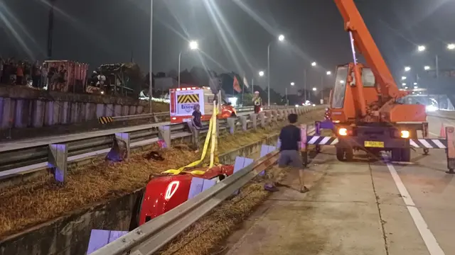 Petugas PJR mengevakuasi mobil Porche merah saat terguling di Tol Desari, Depok. (Istimewa)