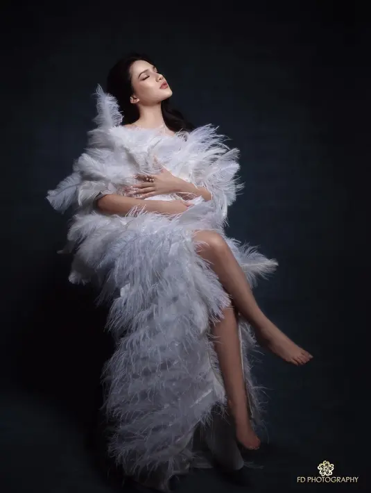 Gaun putih asimetris penuh bulu itu diketahui adalah rancangan Irene Danielle [@davinaakaramoy]