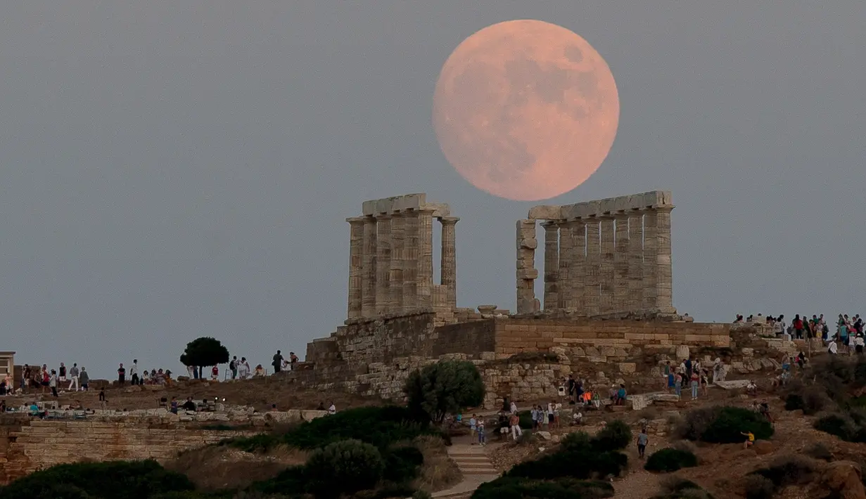 Pemandangan bulan purnama hampir penuh yang menampakkan diri di langit Kuil Poseidon kuno di Cape Sounion, sekitar 70 kilometer sebelah tenggara Athena, Yunani (2/8/2020). (Xinhua/Marios Lolos)