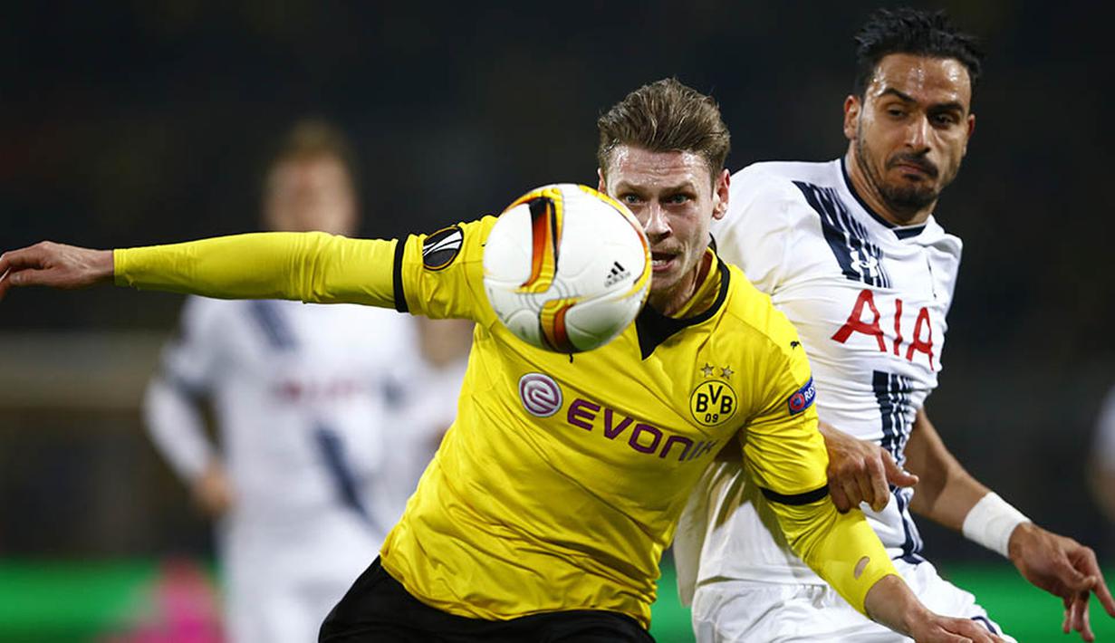 Bek Dortmund, Lukasz Piszcek, mengamankan bola dari kejaran penyerang Tottenham, Nacer Chadli. Pada laga itu wasit hanya mengeluarkan dua kartu kuning dan keduanya untuk pemain Tottenham. (Reuters/Wolfgang Rattay)