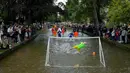 Pemain sepak bola Bourton Rovers berebut bola dalam pertandingan sepak bola tradisional tahunan River Windrush di Desa Cotswolds, Bourton-on-the-Water, Inggris, Senin (28/8/2023). (AP Photo/Frank Augstein)