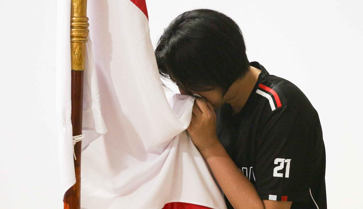 Pemain Timnas voli putri Indonesia mencium bendera Merah Putih saat upacara pelepasan di Padepokan Voli Jenderal Polisi Kunarto, Sentul, Jawa Barat, Selasa (2/6/2026). (Bola.com/Abdul Aziz)