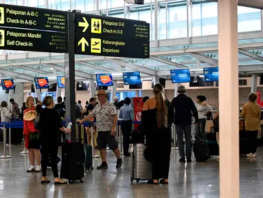 Para penumpang menunggu di tengah gangguan penerbangan akibat serangan Israel-Amerika Serikat terhadap Iran, di Bandara Internasional I Gusti Ngurah Rai, Bali, pada Senin 2 Maret 2026. Penutupan ruang udara di sejumlah negara kawasan Timur Tengah berimbas pada pembatalan sejumlah penerbangan oleh maskapai di dua Bandar Udara (Bandara) Internasional di Indonesia. (SONNY TUMBELAKA/AFP)