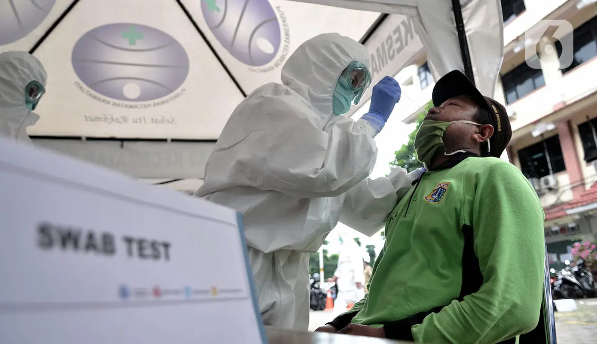 Petugas medis melakukan tes swab COVID-19 terhadap peserta di Kantor Kecamatan Kramat Jati, Jakarta, Selasa (16/6/2020). Puskesmas Kecamatan Kramat Jati menggelar tes swab bagi seluruh pegawai instansi pemerintahan untuk memutus rantai penyebaran COVID-19. (merdeka.com/Iqbal Nugroho)