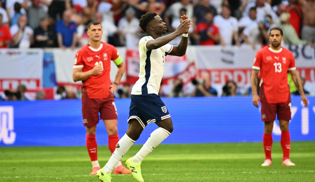 Lima menit berselang, Bukayo Saka mencetak gol penyeimbang untuk Inggris. (Alberto PIZZOLI/AFP)