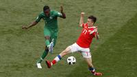 Aksi pemain Arab Saudi, Omar Othman (kiri) melepaskan tembaan saat diadang pemain Rusia, Alexander Golovin pada laga grup A Piala Dunia 2018 di Luzhniki stadium, Moskow, Rusia, (14/6/2018). Rusia menang 5-0. (AP/Darko Bandic)