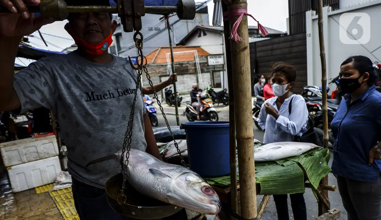 Pedagang menimbang ikan bandeng saat melayani pembeli di kawasan Rawa Belong, Jakarta Barat, Rabu (10/2/2021). Jelang Tahun Baru Imlek 2021, para pedagang ikan bandeng mulai bermunculan di Rawa Belong. (Liputan6.com/Johan Tallo)