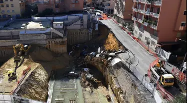 Sebuah jalanan ambles di distrik Balduina, kawasan barat ibu kota Italia, Roma, Kamis (15/2). Sedikitnya enam mobil terperosok ke dalam lubang berkedalaman 10 meter tersebut. (AFP PHOTO / TIZIANA FABI)