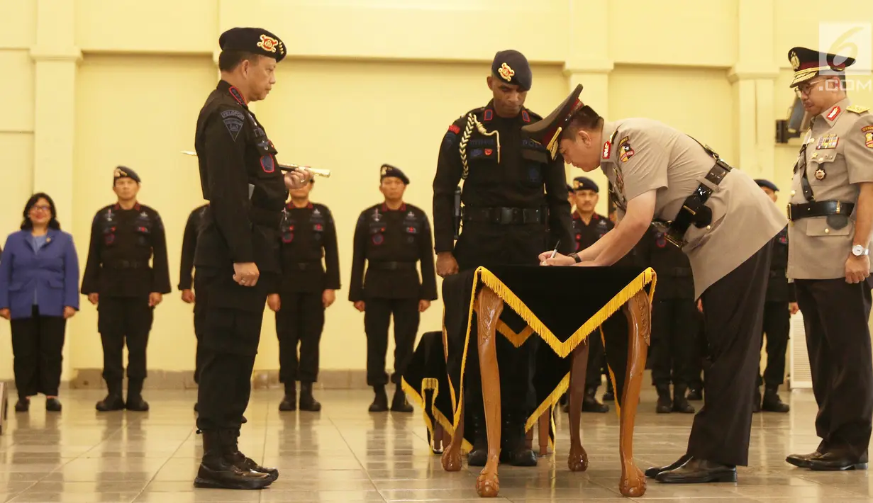 Kapolri Jenderal Tito Karnavian menyaksikan Brigjen Muhammad Iqbal menandatangani dokumen pelantikan selama upacara sertijab di Mako Brimob, Kelapa Dua, Depok, Rabu (14/11). Brigjen Muhammad Iqbal kini menjabat Kadiv Humas. (Liputan6.com/Herman Zakharia)