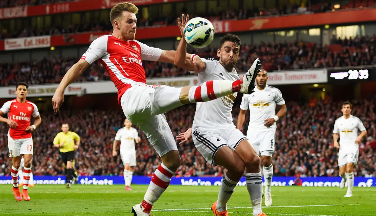 Gelandang Arsenal, Aaron Ramsey (kedua kiri) berebut bola dengan bek Swansea City Neil Taylor saat Laga Liga Premier Inggris di Emirates Stadium, Selasa (12/5/2015). Swansea City menang 1-0 atas Arsenal. (Reuters/ADylan Martinez)