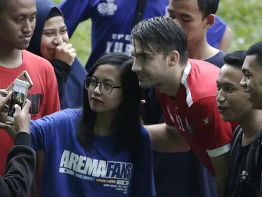 Pemain Arema FC, Pavel Smolyachenko, foto bersama fans usai sesi latihan di Stadion Gajayana, Malang, Kamis (11/4). Setelah sesi latihan, pemain Arema FC melayani permintaan fans untuk foto bersama. (Bola.com/Yoppy Renato)