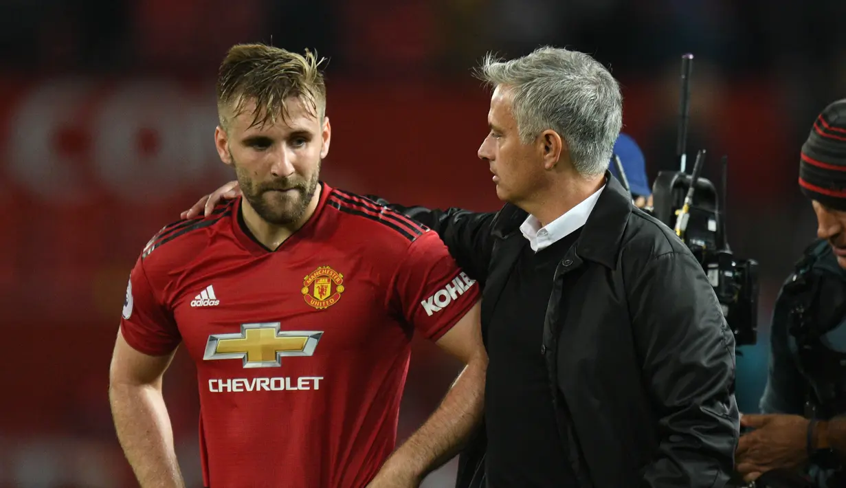 Pelatih Manchester United, Jose Mourinho merangkul bek Luke Shaw usai pertandingan melawan Tottenham Hotspur pada lanjutan Liga Inggris di Old Trafford, (27/8). MU kalah telak atas tottenham 3-0. (AFP Photo/Oli Scarff)