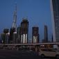 Sebuah taksi melintasi Jalan Sheikh Zayed 12 dekat Burj Khalifa, Dubai, Uni Emirat Arab, Minggu (5/4/2020). Pemerintah Dubai memberlakukan lockdown mulai 5 April 2020. (AP Photo/Jon Gambrell)